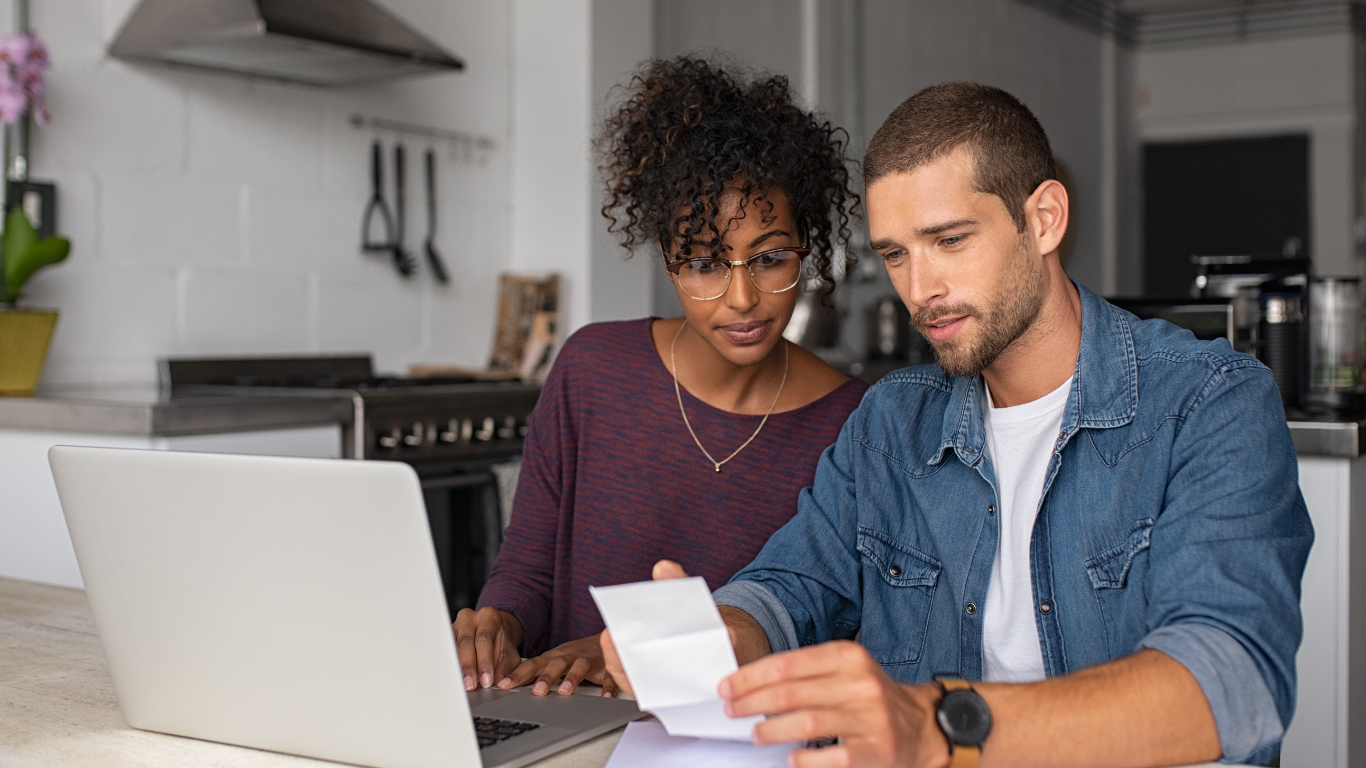 Casal no computador pesquisando sobre finanças.