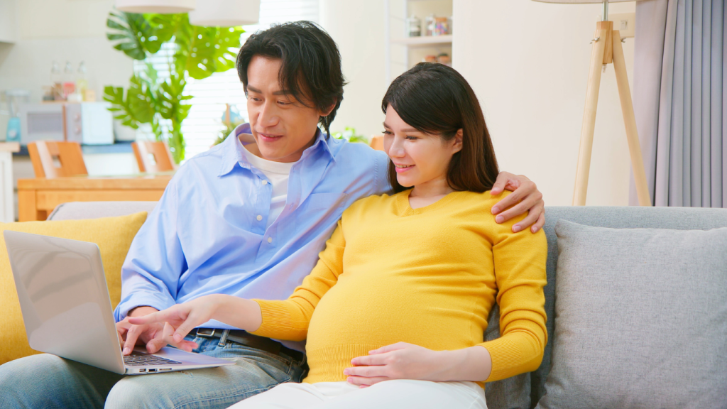 Casal esperando um filho com notebook na mesa planejando financeiramente.